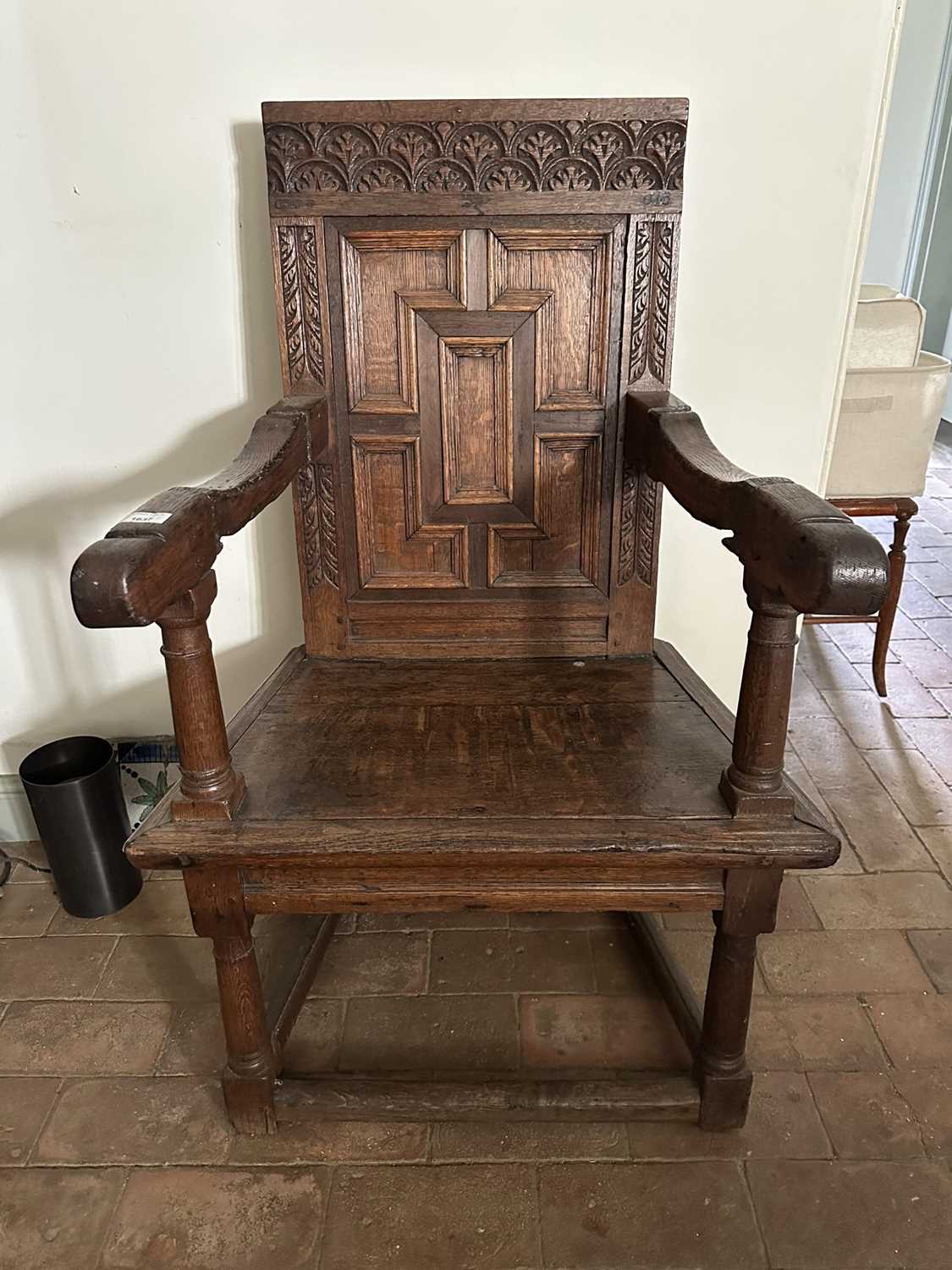 Lot 1637 - 17th century and later oak elbow chair, the panelled square back above a solid seat, turned supports joined by stretchers