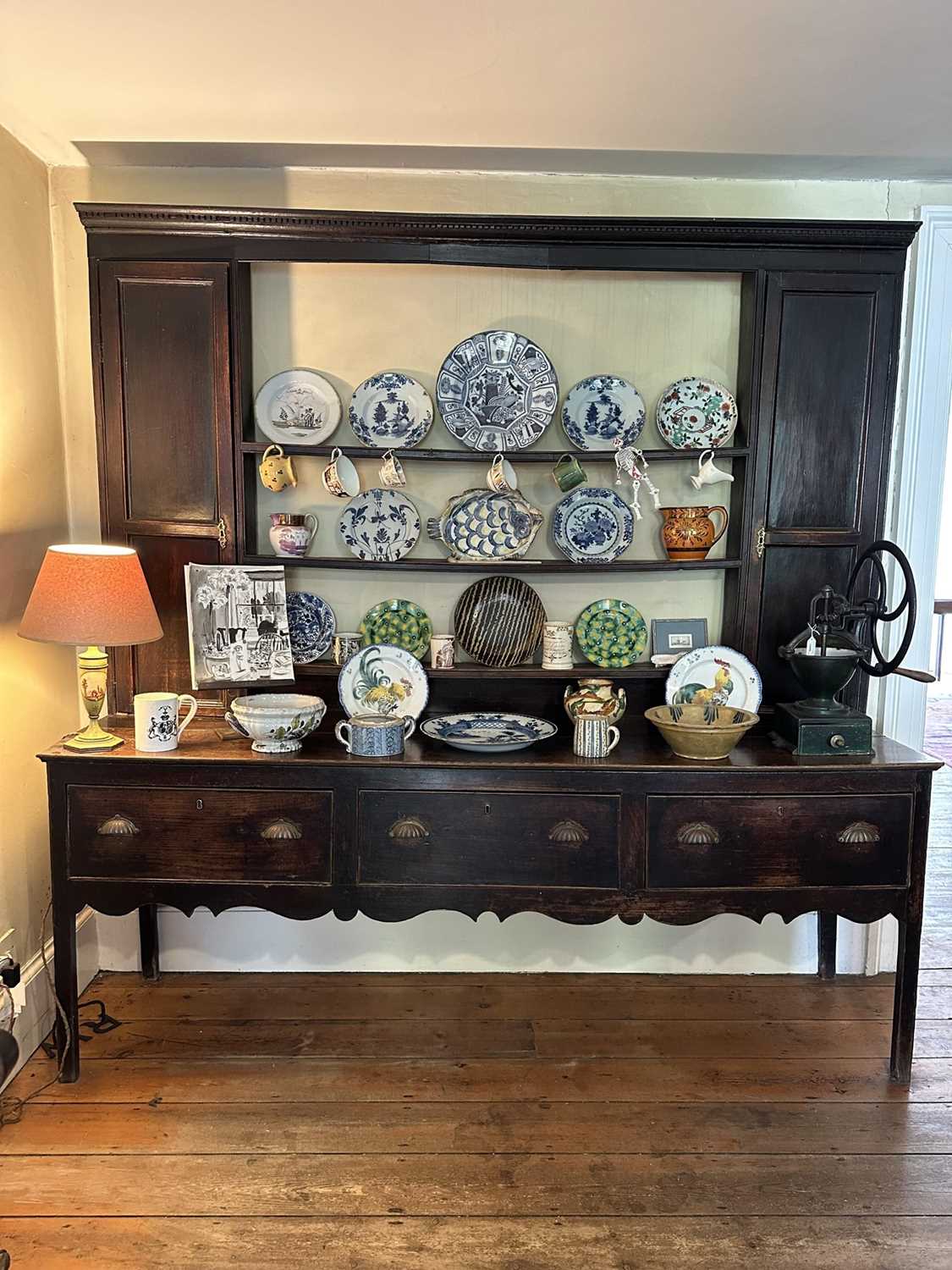 Lot 1638 - 18th century oak two height dresser, the central open shelves flanked by twin cupboards, three drawers below, on square legs