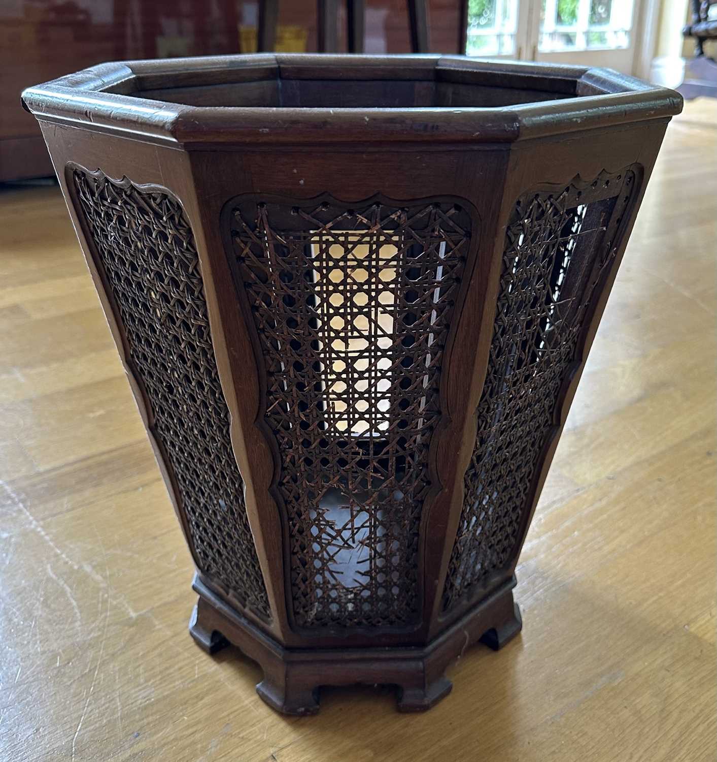 Lot 1612 - 1920s mahogany wastepaper basket of octagonal tapering form with cane work panels, 37cm high
