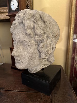 Lot 1563 - Carved stone head of a youth, possibly Mediaeval, presented on a wooden plinth