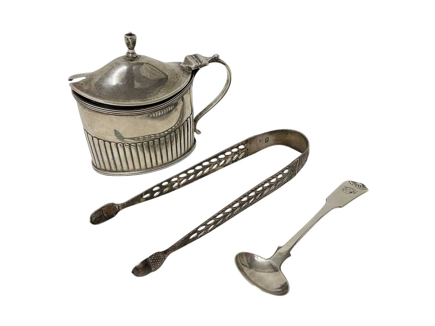 Lot 1600 - Victorian silver mustard pot with half reeded body and blue glass liner (London 1892), a Victorian Glasgow silver spoon and a pair of Georgian silver sugar tongs