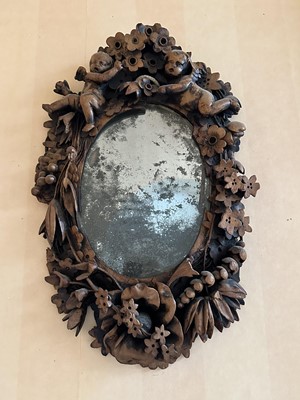 Lot 1656 - Antique Continental carved fruitwood mirror with ornate putti and foliate frame, 39cm x 26cm