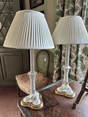 Lot 1707 - Pair of antique white glazed candlesticks with mythical dolphin supports, converted to table lamps, on shaped gilt wood bases