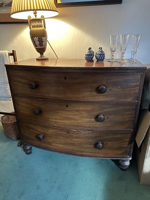 Lot 1723 - Early Victorian mahogany bow front chest of three long drawers, with bun handles, on turned feet, 91cm wide x 47cm deep