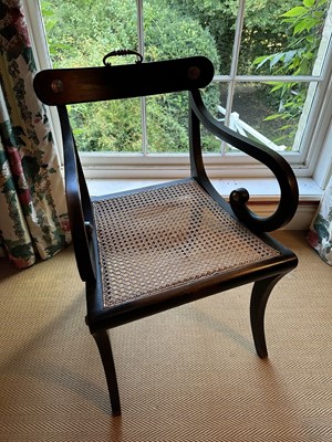 Lot 1758 - Regency ebonised open elbow chair with brass mounts, cane work seat and sabre legs