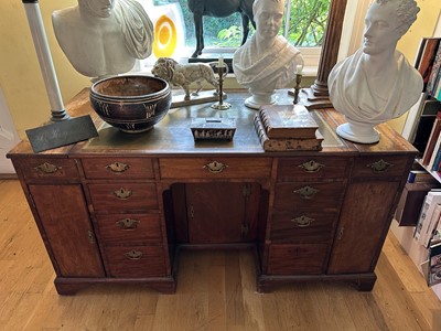 Lot 1798 - 19th century Estate desk, mahogany, leather lined top above an arrangement of nine drawers, a pair of deep cupboards, all surrounding a central kneehole, on bracket feet