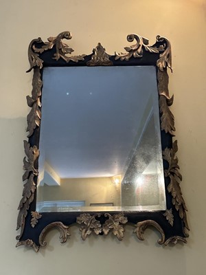 Lot 1813 - 18th century ebonised and gilt wall mirror with foliate scroll and oak leaf carvings, 84cm high x 58cm wide.