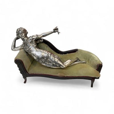 Lot 5034 - Unusual chrome car mascot of a woman holding a wine glass, mounted on to a miniature chaise longue