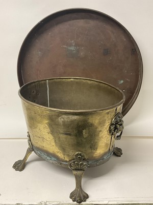 Lot 242 - Antique brass planter / log bin with lion's head ring handles on paw feet, together with a large copper tray/lid (2)