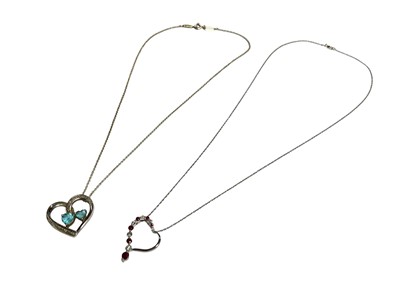 Lot 53 - Diamond and ruby 9ct white gold heart pendant on chain and a diamond and blue topaz silver heart shaped pendant on chain (2)