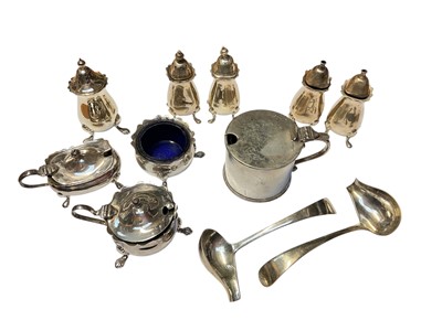 Lot 154 - George V silver mustard pot of drum form, (London 1934), together with a pair of silver cream ladles and a silver eight piece condiment, (various dates and makers), all at 16.5ozs.
