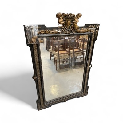 Lot 5400 - Antique ebonised and gilt gesso wall mirror with putti and shield cresting and rectangular plate within moulded slip frame, 140cm x 96cm