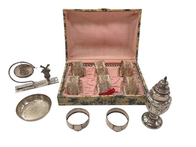 Lot 913 - Edwardian silver pepper pot, pair of silver napkin rings, set of six white metal filigree napkin rings in case, plated pin dish and plated Dutch souvenir ornament