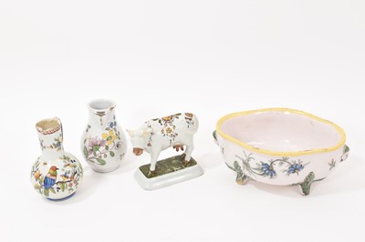 Lot 242 - Early / mid 18th century Dutch Delft tin-glazed cow, a late 18th century French tin-glazed sparrow beak jug, one other jug and a small basin raised on feet. (4 pieces)