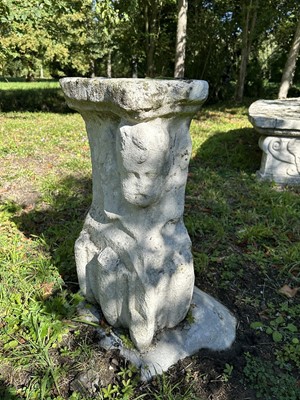 Lot 1935 - Pair of 17th / 18th century carved stone mounts, each with winged cherubic figures, approximately 70cm high, set into a concrete base