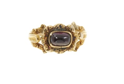 Lot 556 - Regency garnet ring with a cabochon garnet in foliate gold setting