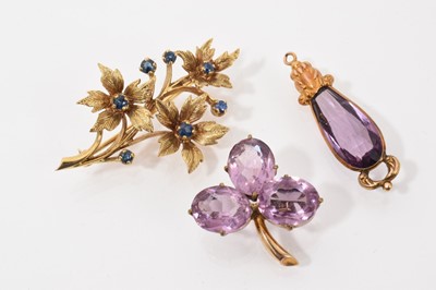 Lot 703 - 9ct gold sapphire floral spray brooch, an amethyst three stone cloverleaf brooch and and an antique faceted purple stone drop pendant (3)