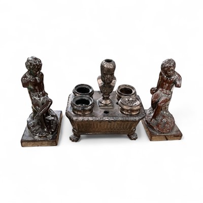 Lot 20 - 19th century lustre pottery inkstand, with figural pen holder, four inkwells, fluted oblong form body and lion's paw feet, 20cm high, together with a pair of similar cherub figures (3)