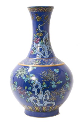 Lot 239 - Chinese blue ground bottle vase, Guangxu mark, 19th / 20th century, decorated in raised enamels with blossoming trees and flowers issuing from rockwork, 38.5cm high