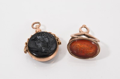 Lot 731 - Antique 9ct gold mounted rotating hard stone seal, the carved circular panel depicting a Roman soldier's head, together with one other yellow metal carved carnelian seal depicting a male bust (2)