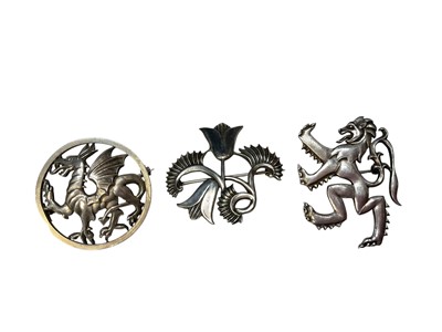 Lot 8 - Two George Tarratt silver brooches designed by Geoffrey Guy Bellamy to include a dragon, no. 222 and abstract flowers, no. 179, together with an Ivan Tarratt rampant lion brooch by the same desi...