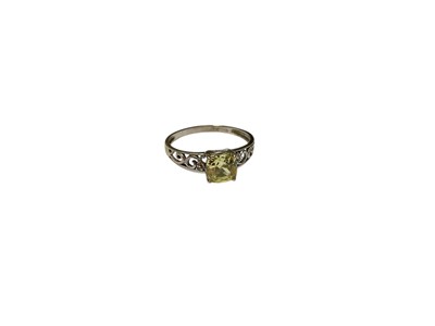 Lot 46 - Single stone ring with a cushion cut fancy yellow stone in 9ct white gold open work scroll setting, size O