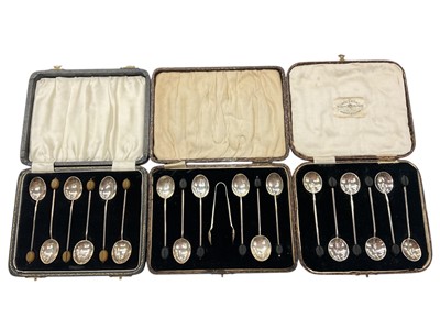 Lot 959 - Three sets of six silver bean end coffee spoons, one with a pair of silver sugar tongs, all in fitted cases