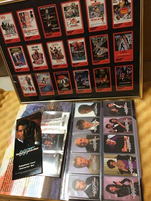 Lot 345 - James Bond 007 collectors' telephone cards mounted in a glazed frame and Tomorrow Never Dies presentation pack