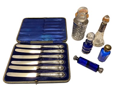 Lot 163 - Set of six Edwardian silver handled butter knives in a fitted case, (Sheffield 1908), together with a glass bottle within a silver holder, double ended scent bottle and three other perfume bottles