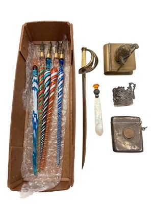 Lot 1020 - Silver vesta case with a coin insert, small silver cup holder, brass stamp holder in the form of a book with bear surmount, mother of pearl bookmark, letter opener in the form of a sword and fiv...