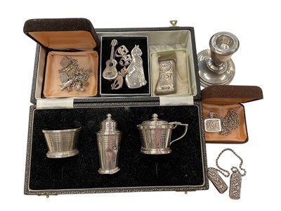 Lot 1029 - Silver three piece condiment set in case, silver candlestick, silver charm bracelet and other silver/white metal jewellery