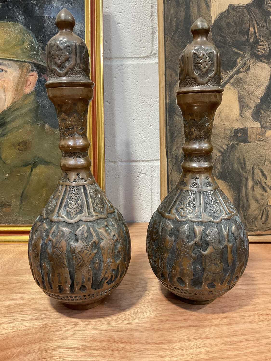 Lot 5091 - Pair of Islamic copper bottle vases and covers with relief decoration, 36.5cm high