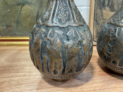 Lot 5091 - Pair of Islamic copper bottle vases and covers with relief decoration, 36.5cm high