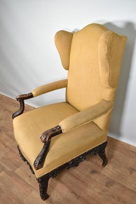 Lot 1220 - 18th century Continental wing armchair, with heavily carved scroll arms on cabriole legs