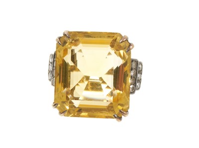 Lot 604 - Art Deco citrine and diamond cocktail ring with a large rectangular step-cut citrine measuring approximately 19.75 x 17.1 x 10.8mm, flanked by stepped shoulders with single-cut diamonds, on tape...