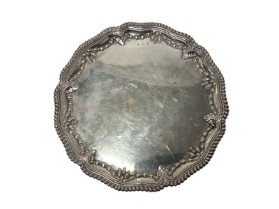 Lot 435 - Edwardian silver salver of circular form with embossed swag decoration and gadrooned border, raised on three bun feet, (Birmingham 1901), maker Elkington & Co, 31.5cm in diameter, all at 28o...