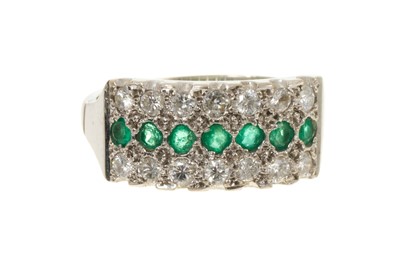 Lot 711 - Emerald and diamond triple row ring with a central band of mixed-cut emeralds flanked by two rows of brilliant cut diamonds in 18ct white gold setting, ring size P½.