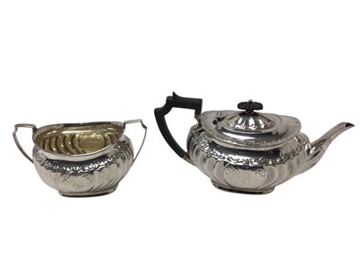 Lot 449 - Victorian silver teapot of cauldron form, with fluted decoration, domed hinged cover and angular ebonised handle, together with matching sugar bowl, both with engraved initial D, (Sheffield 189...