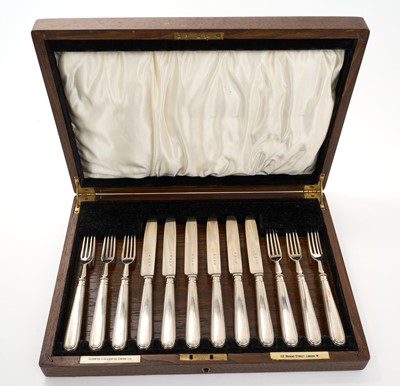 Lot 478 - Set of six George V silver dessert / fruit knives and forks, (London 1934), maker Goldsmiths & Silversmiths Company Ltd, in a fitted oak canteen with inset brass cartouche and ivorine retaile...