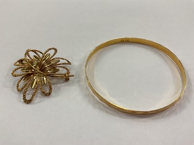 Lot 958 - Yellow metal bangle stamped '18ct' and 9ct gold abstract floral brooch (2)