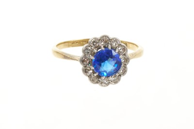 Lot 657 - Antique sapphire and diamond cluster ring with a round mixed cut blue sapphire measuring approximately 6mm diameter x 4mm deep, surrounded by a border of single cut diamonds in platinum setting...
