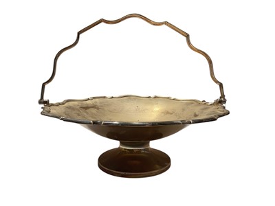 Lot 101 - George V silver cake basket of circular form with pierced crust border and swing handle, raised on a pedestal foot, (Sheffield 1921), maker R F Mosley & Co, 24.5cm in diameter, all at 21ozs....