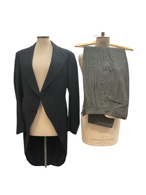Lot 2544 - Vintage legal and academic tailoring by Ede & Ravenscroft including two black gowns with extended sleeves and sashes, black Court style jacket, 1934 black tailcoat with pin-stripe trousers....