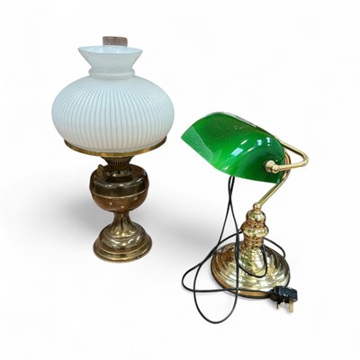 Lot 5000 - Brass oil lamp with a white glass shade, together with a brass desk lamp with green glass shade (2)