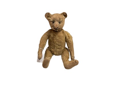 Lot 1934 - Antique bear, possibly Steiff, much loved, three section constructed head, boot button eyes, long snout, long limbs, hump, four stitched claws, wood wool and soft stuffing. 30 cms approximately....