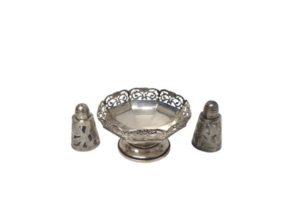 Lot 259 - Silver octagonal bonbon dish with pierced decoration (Birmingham 1911), together with a pair of Mexican silver and glass pepperettes (3)