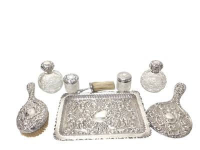 Lot 323 - Edwardian silver dressing table items to include a rectangular tray, brushes, mirror and four glass jars/ scent bottles