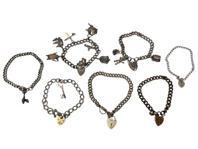 Lot 136 - Group of silver curb link bracelets with padlock clasps, some with charms (7)