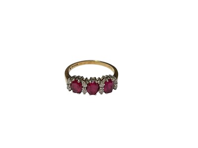 Lot 294 - 9ct gold synthetic ruby three stone ring interspaced with brilliant cut diamonds, size L½