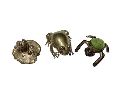 Lot 218 - Contemporary silver pill box in the form of a frog on a lily pad, (Birmingham 1983), a silver frog pin cushion and another silver frog, all at 2.0oz...
